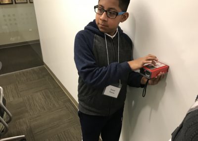 Student uses a digital measuring tool to measure the room
